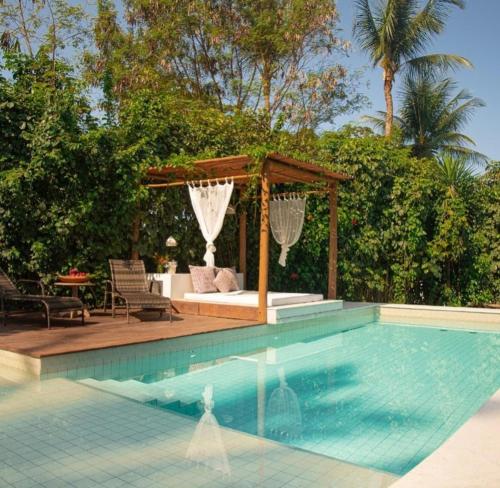 a swimming pool with a gazebo and a gazebo at Casa Ibiza Arraial d'Ajuda in Arraial d'Ajuda