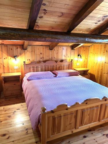 a bedroom with a large wooden bed in a cabin at The WoodHouse in Livigno