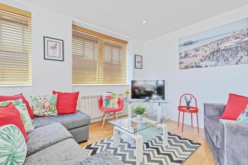 a living room with two couches and a tv at Urban Heights By My Getaways in Brighton & Hove