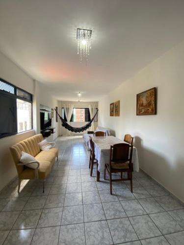 a living room with a table and a couch at Apartamento amplo e confortavel in Cabedelo