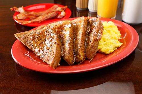 due piatti rossi con pane tostato e uova su un tavolo di Riverwalk Casino Hotel a Vicksburg