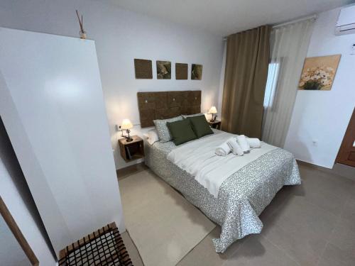 a bedroom with a bed with towels on it at Alojamiento La Cartera I Alto del Garruchal in El Caracolero