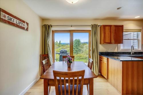 a kitchen with a wooden table with chairs and a window at Hillcrest #1 in Stowe