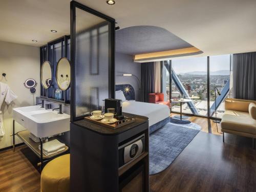 a bathroom with a bed and a sink and a mirror at Novotel Mexico City World Trade Center in Mexico City
