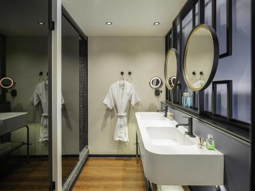 a bathroom with two sinks and a mirror at Novotel Mexico City World Trade Center in Mexico City