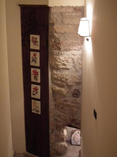 a hallway with a stone wall with a light on it at Case Brizi Assisi in Assisi