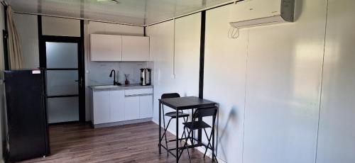 a small kitchen with a stool and a table in it at הבקתות של מאי 