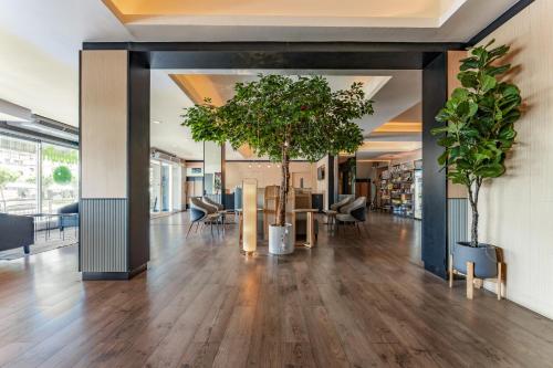a lobby with trees and chairs in a building at Golden Jade Suvarnabhumi in Lat Krabang