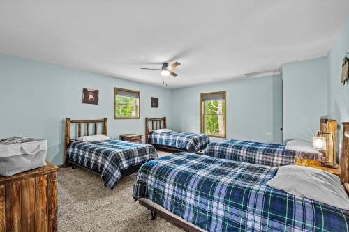 a bedroom with two beds and two windows at Hot Tub and Community Beach Albrightsville Home! in Albrightsville