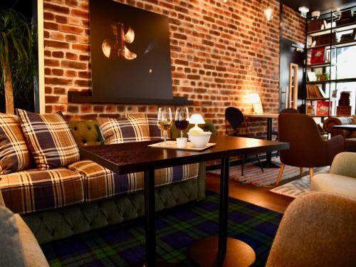a room with a couch and a table with wine glasses at ibis budget Saint Nazaire Centre Gare in Saint-Nazaire