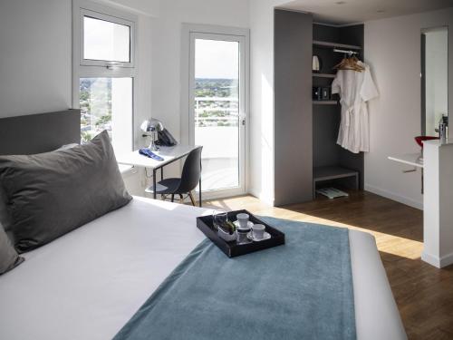 a bedroom with a white bed with a tray on it at Mercure Rosario in Rosario