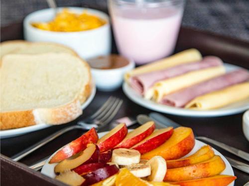 una mesa con platos de comida con manzanas y pan en Mercure Rosario, en Rosario