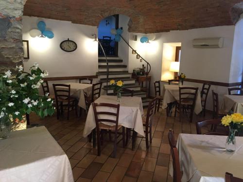 a restaurant with tables and chairs and a clock on the wall at Il Portico in Carrosio
