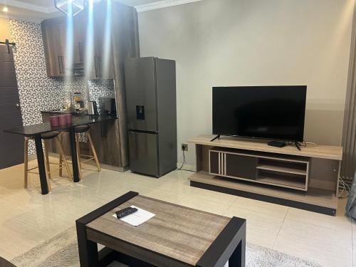 Una sala de estar con un televisor de pantalla plana en un centro de entretenimiento. en Mountain Top Luxury Villas, en Mbabane