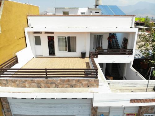 a white house with a porch and stairs at Casa Ba-Al, Bonito departamento a 5 minutos del centro de Oaxaca in Oaxaca City