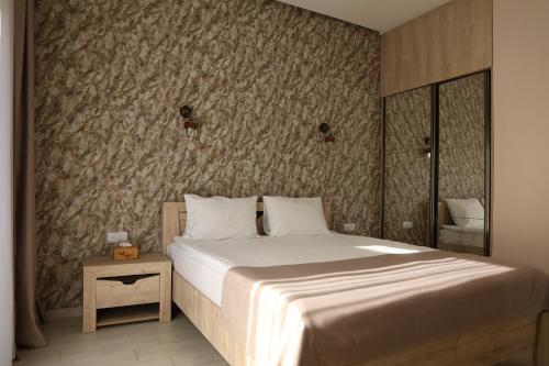a bedroom with a large bed and a wall at Harmony Resort in Tsaghkadzor