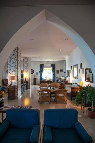 a large living room with blue couches and chairs at Park Hotel Silemi in Letojanni