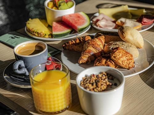 a table topped with plates of breakfast foods and drinks at Hotel Valkenburg by Mercure - Next to Shimano Experience Center in Valkenburg