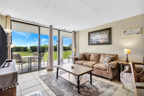 una sala de estar con un sofá y una mesa en Direct Oceanfront Condo Beautifully Remodeled, en Cabo Cañaveral
