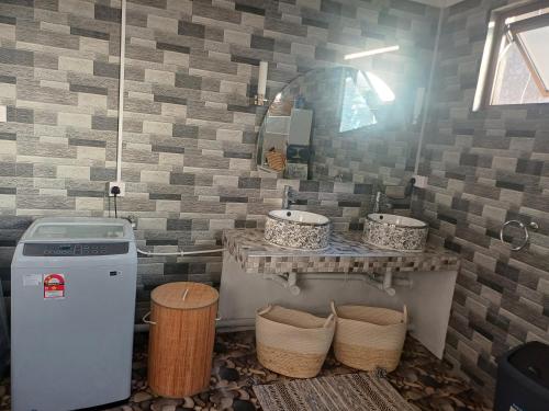 a bathroom with two sinks and a mirror and baskets at Trich Studio in La Gaulette