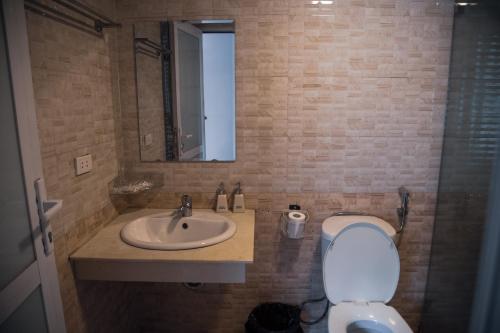 a bathroom with a sink and a toilet and a mirror at Sapa Central House in Sa Pa