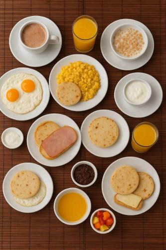 Una mesa con platos de desayuno y bebidas. en Casa Hotel Boyaca Real, en Bogotá