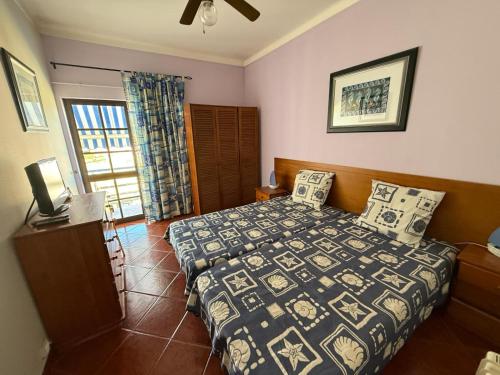 a bedroom with a bed and a television in it at Villa Vau in Portimão