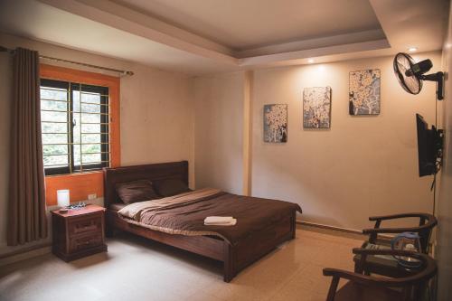 a bedroom with a bed and a table and a window at Sapa Central House in Sa Pa