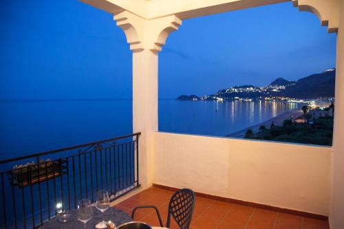 a balcony with a view of the water at night at Park Hotel Silemi in Letojanni