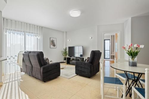 a living room with two chairs and a table at Fórum Glam 5B by Homie in Ilhéu do Gorgulho