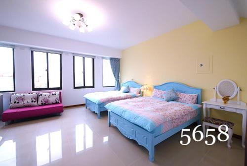 un dormitorio con dos camas y un sofá en Country Style Anping Homestay, en Tainan