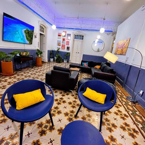 a living room with two blue tables and yellow pillows at Casa Amelio Roma Norte in Mexico City