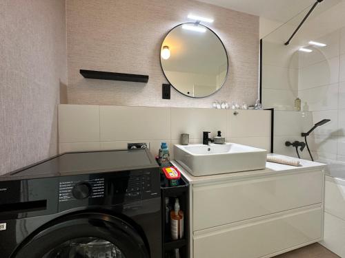 a bathroom with a sink and a washing machine at Labutia, self-checkin, parking, AC in Bratislava