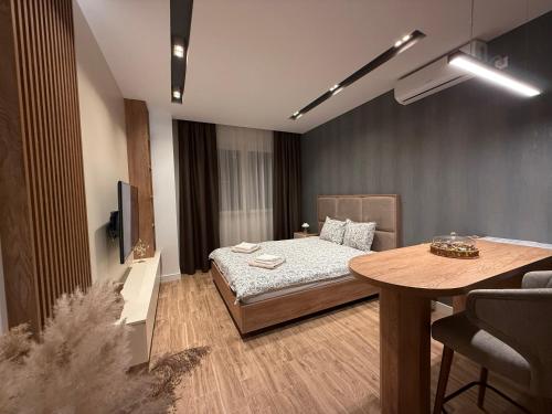 a room with a bed and a table in it at IL PRIMO Studio Apartment in Kragujevac