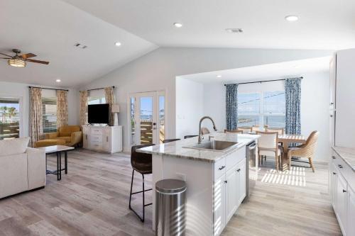 a kitchen and living room with a sink and a table at Blue Beak Bungalow in Pensacola