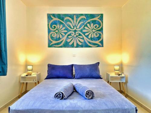 a bedroom with a bed with two pillows on it at Charmant logement avec accès privé à la plage in Moorea