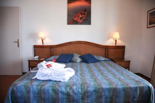 a bedroom with a bed with a robe on it at Park Hotel Silemi in Letojanni