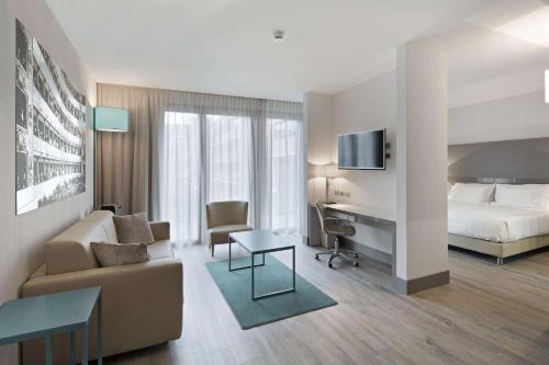 una habitación de hotel con una cama y un escritorio en NH Parma, en Parma