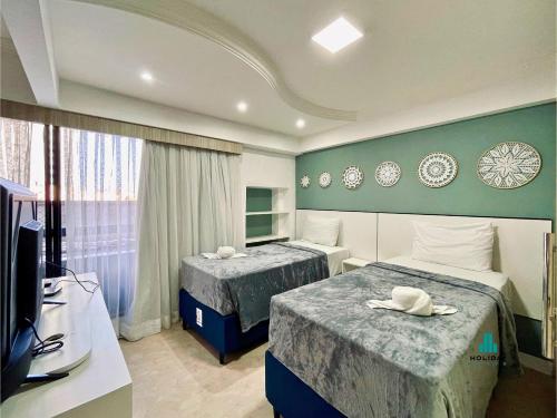 een hotelkamer met twee bedden en een televisie bij Scala Residenza By Holiday Stays in Fortaleza