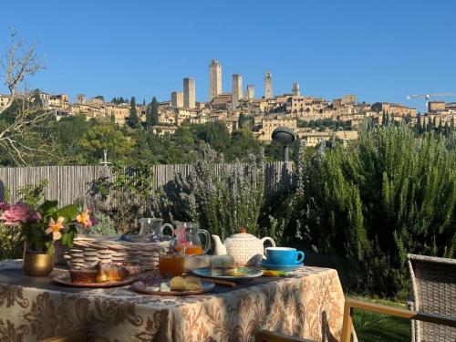a table with food on it with a view of a city at B&B Il Fienile San Gimignano in San Gimignano