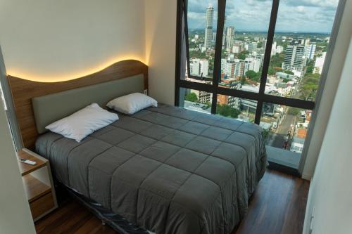 a bedroom with a bed with a large window at Luxury 2 Bedroom "Wake Up in the Sky" Best Views & Location in Asuncion in Asuncion