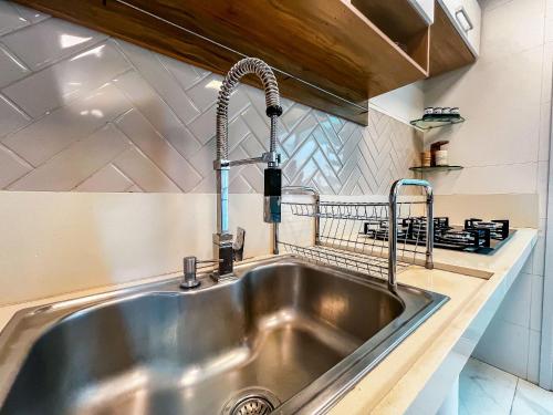 a stainless steel kitchen sink with a faucet at Casa Vista Mar com piscina na Orla De Atalaia in Santa Maria