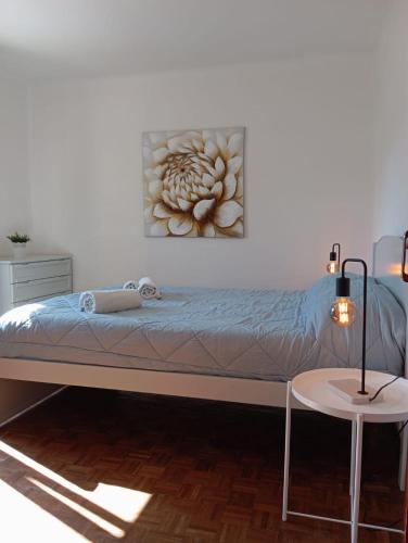 a bed in a room with a painting on the wall at Villa Gonçalo in Caldas da Rainha