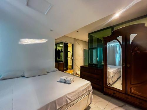 a bedroom with a large bed and a large mirror at Casa Vista Mar com piscina na Orla De Atalaia in Santa Maria