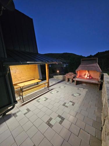 a patio with two benches and a fire pit at Luxury Villa Mašić in Čardaci
