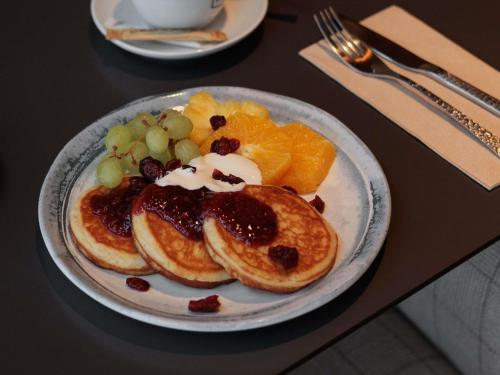 un plato de tortitas y fruta en una mesa en Mercure Tallinn, en Tallin