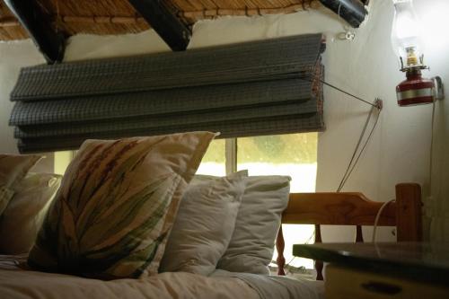 a bed with pillows in a bedroom with a window at Blackbrook Farm Underberg in Underberg