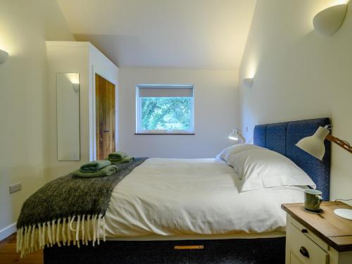 a bedroom with a large bed with a window at 1 Bed in Talybont-on-Usk 88138 in Talybont