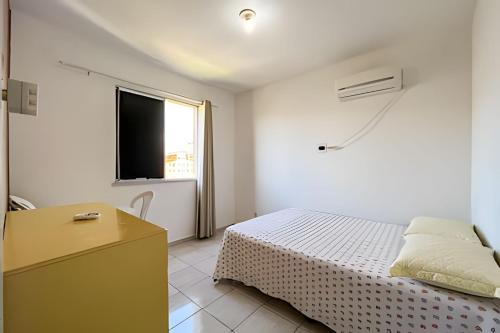 a white bedroom with a bed and a window at Apto com AR, 3/4 em condomínio com piscina e lazer in Aracaju