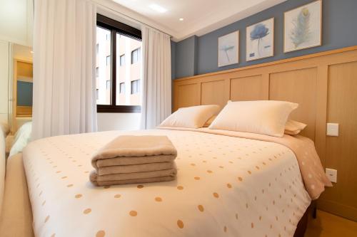a bedroom with a bed with two towels on it at 1306 - Luxuoso Studio BF - CWB Central - Com Garagem in Curitiba